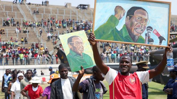 Un grupo de simpatizantes sostiene retratos de Mugabe, este viernes en Zimbabue