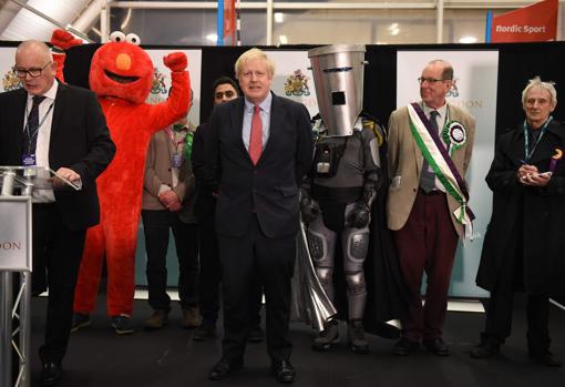 Johnson, antes de comparecer, junto a Elmo y un «superhéroe»