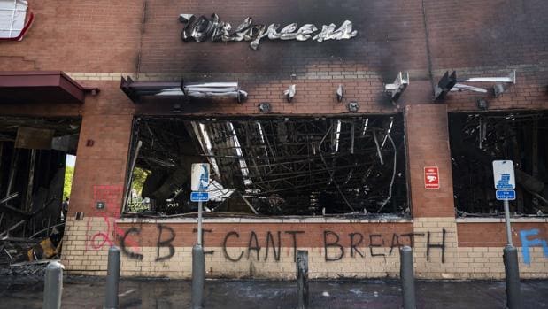 Estado de unos almacenes quemados en Mineápolis, en cuya fachada se puede leer la última frase que dijo Floyd: «I can't breath« (No puedo respirar), que se ha convertido en el lema de las protestas