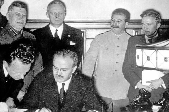 Stalin (segundo por la izquierda) sonríe junto al ministro ruso de Exteriores, Vyacheslav Mólotov, mientras firma el ministro alemán, Joachim von Ribbentrop