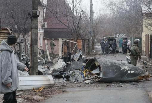 Un hombre mira los restos de un avión militar derribado durante la noche en Kiev