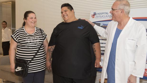 Juan Manuel Heredia (c),, el hombre más obeso de España que este año ha llegado a pesar 300 kilos, acompañado de su esposa y del doctor Carlos Ballesta, momentos antes de someterse a la intervención de un novedoso bypass gástrico por laparoscopia para combatir su obesidad extrema
