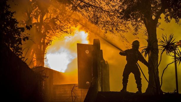 Un bombero trabaja en la extinción de un incendio en Funchal, isla de Madeira