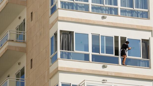 Una empleada del servicio de limpieza limpia la ventana de un hotel en Palma de Mallorca