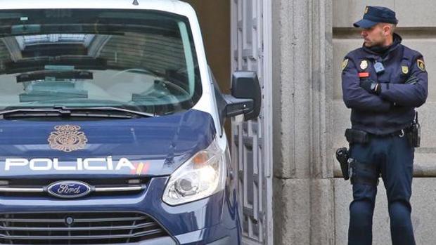 Imagen de un coche y un guardia de la Policía Nacional