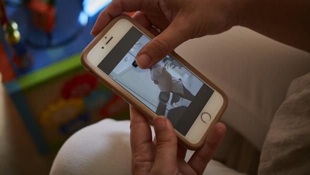 Una mujer muestra la foto de su gestante embarazada