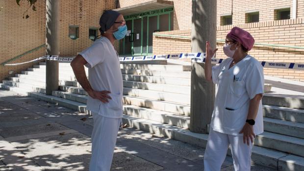 Dos sanitarios conversan ayer en las inmediaciones del polideportivo Cortes de Aragón de Fraga, donde hay algunas personas que han dado positivo