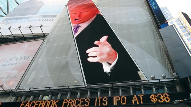 Una imagen de Donald Trump preside una pantalla digital en donde se muestran datos bursátiles